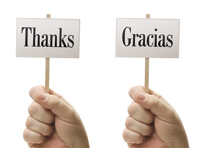 Three Signs In Male Fists Saying Merci, Thanks and Gracias Isolated on a White Background.